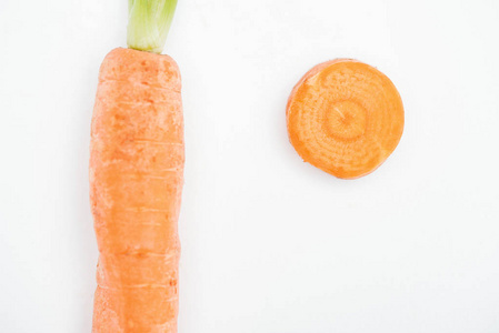 新鲜熟生胡萝卜和胡萝卜片的顶部视图，分离在白色上
