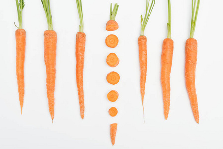 顶部的构图与整个胡萝卜与一个切片胡萝卜在中心隔离在白色。