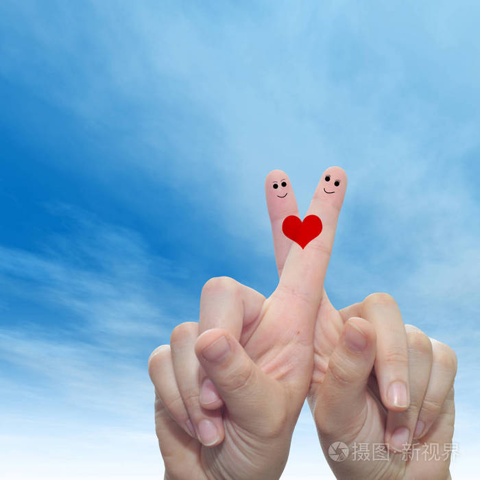 概念或概念人类或女性的双手，两个手指涂着红色的心，微笑的脸在云蓝色的天空背景上