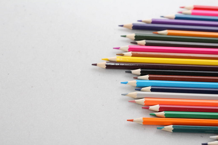 小学生和学生的彩色铅笔。铅笔散落在一张白色的桌子上，站在玻璃里。上班族的铅笔..