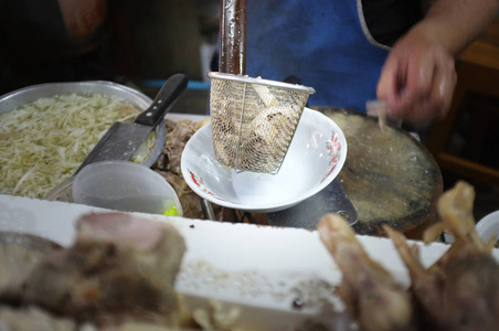 厨师烹饪面条与猪肉和猪肉内脏在当地餐厅泰国街头食品在萨肯纳洪泰国。