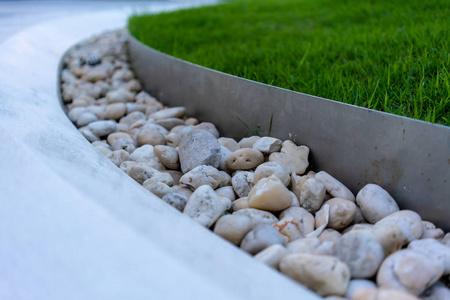 公共空间设计白色曲线石凳装饰白色砾石和草坪. 为了公共空间.