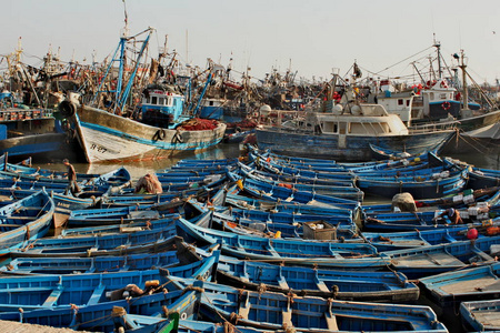 摩洛哥的埃萨乌伊拉市。 许多蓝色的小传统渔夫船在当地港口。 船在水上互相靠近。