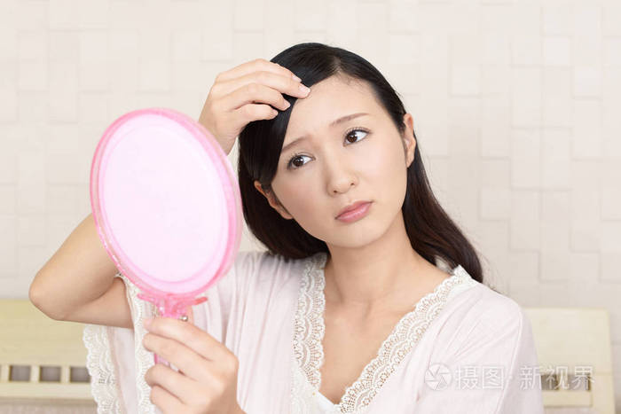 亚洲女人照镜子看她的脸