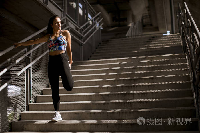 年轻的健身妇女在城市环境中户外运动