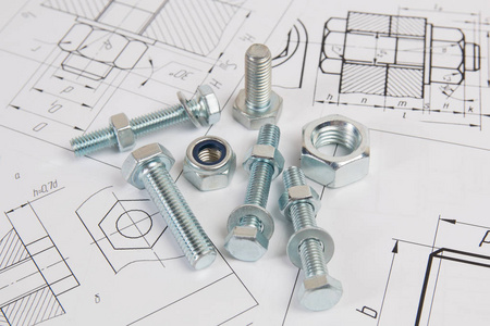 螺栓和螺母的技术图纸..工程，技术和金工..印刷图纸背景上的金属螺栓和螺母。