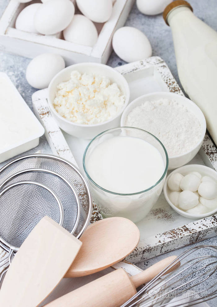 一杯牛奶,一碗面粉和干酪和鸡蛋.盒的烘焙用具.
