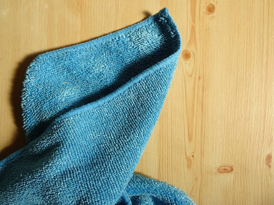 木制背景上的蓝色微纤维毛巾