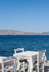 白色餐厅桌子在海滩上的暑假和夏季概念。 提供海景的完美午餐
