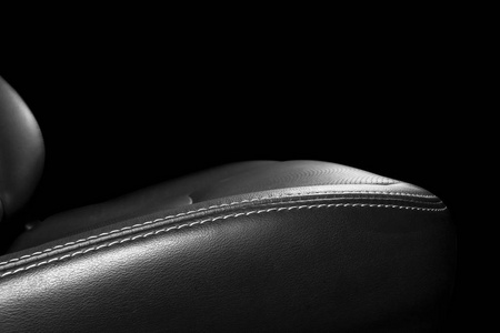 黑色皮革内饰的豪华现代汽车。 穿孔皮革舒适座椅与缝纫隔离在黑色背景。 现代汽车内饰细节。 汽车细节。 汽车里面