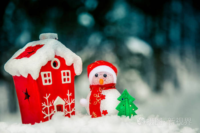 圣诞节组成雪人附近的红色房子在森林