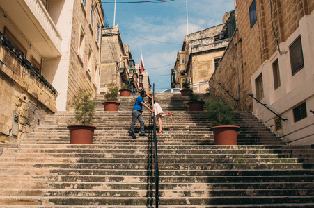 男人和女人在楼梯上走着，亲吻着马耳他三大城市的老城区