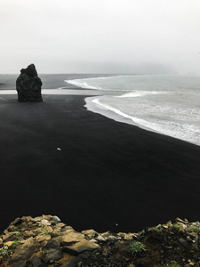 冰岛黑沙滩雷尼斯福吉拉靠近维克镇的戏剧性冬季景观。大雾天气下火山黑滩的风暴海岸