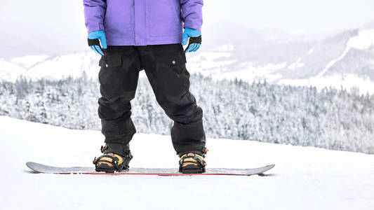 当他站在他的滑雪板上时，近距离拍摄滑雪者的衣服和设备