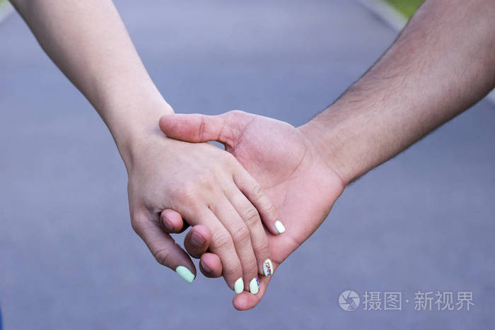 亲密的情侣在爱的手牵着对方的手
