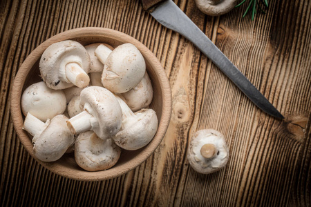 新鲜的白色香菜蘑菇在木碗里。