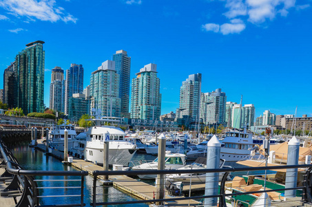 现代摩天大楼港口与豪华游艇在温哥华，BC在明确和美丽的一天