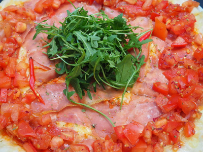 比萨饼与布托帕尔玛火腿阿鲁古拉沙拉火箭和帕尔马背景。 意大利菜