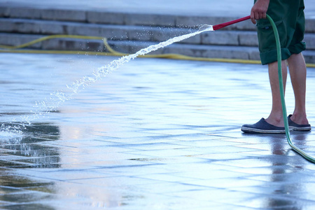 一个给城市街道浇水的水管工人