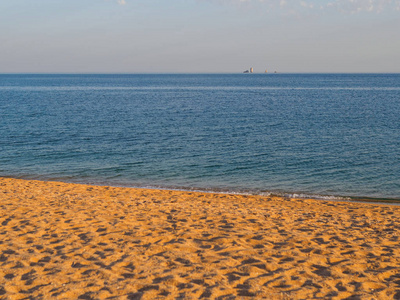 海边的日落。 由圆形贝壳组成的海滩