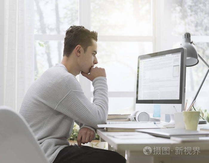 4.聪明的大学生在家使用电脑,他正在上网学习