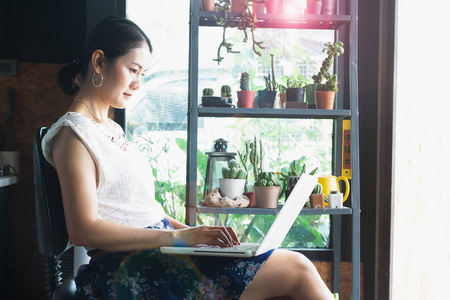 美丽的亚洲女人使用笔记本电脑咖啡馆在线营销业务自由职业者