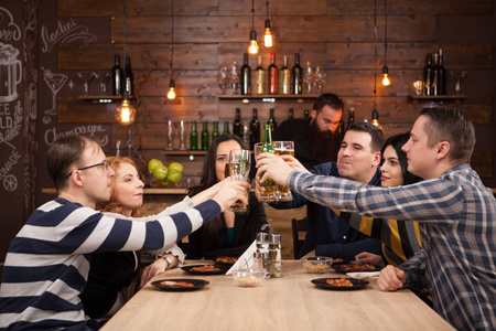 快乐的朋友团体在酒吧餐厅喝啤酒和吃比萨饼