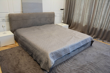 舒适的现代卧室室内设计与豪华床当代灯和窗帘。