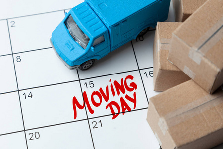 日历上的移动日是用红色写的。日历与纸板箱和卡车的笔记