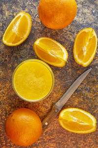 切片橙子和橙汁放在桌子上..黑暗的背景。
