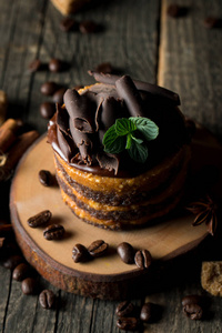 黑色石板上的巧克力蛋糕，黑色背景特写照片上的薄荷咖啡豆。 新鲜美味的甜点食品概念。