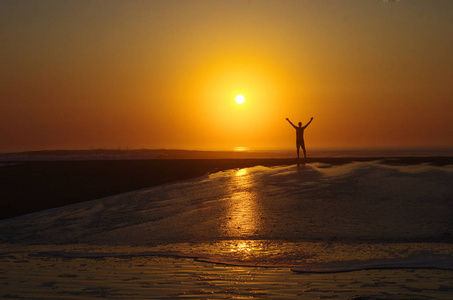 s silhouette against the sun. Sunset on the beach.