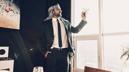 阿拉伯商人。 穿着黑色西装的人。 有经验的企业家。 成功的年轻人。 站在窗边。 绿色办公室。 阿拉伯的肖像。 昂贵的办公室。 由