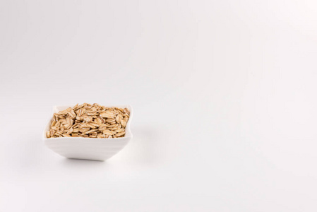 干卷燕麦片在碗中分离在白色背景上。