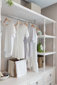 经典衣橱风格,衣服挂白色色调,衣柜,服装内部装饰设计理念照片