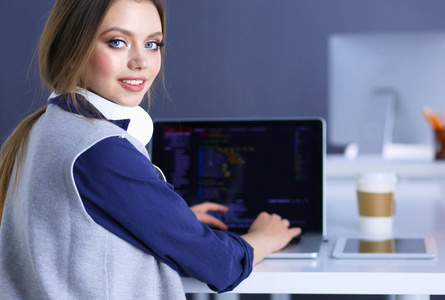 年轻自信的女商人在办公桌前工作, 用笔记本电脑打字