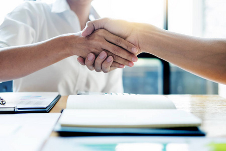 谈生意,两个自信的生意人在会议结束后一起与合作伙伴握手成功的接洽