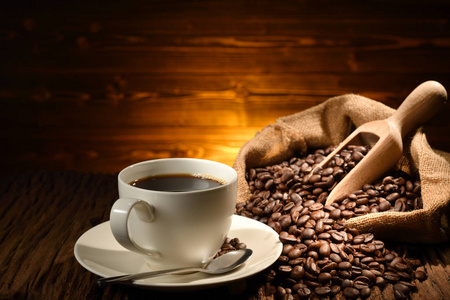 旧木制背景上的一杯咖啡和咖啡豆