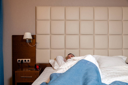 男厨师躺在床上,在酒店房间里穿着制服.