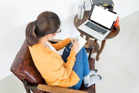 迷人的年轻美丽的企业家女性微笑着看着在家工作的笔记本电脑屏幕
