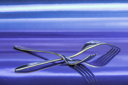 金属蓝色表面上的两个叉子的视图