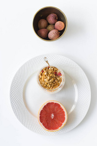 健康早餐的概念。配料柚子，麦片，酸奶，荔枝..俯视图，白底..