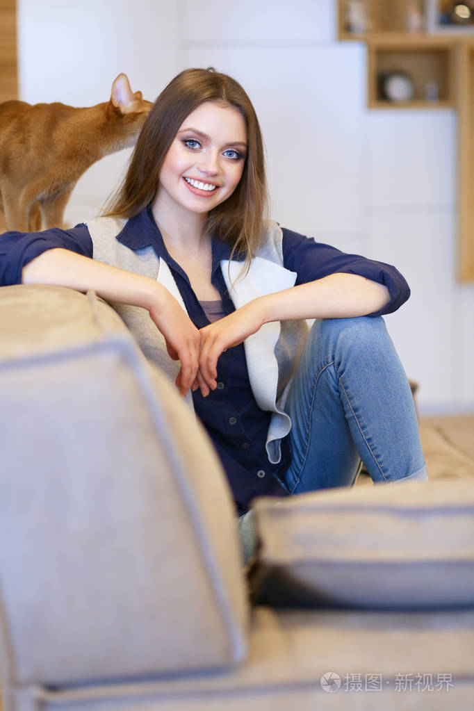 在白色套衫她白色的沙发上坐着的女人