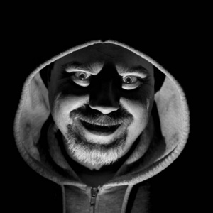 他笑起来像疯子,看起来像疯子.黑白镜头,低调灯光.孤立在黑色上.照片