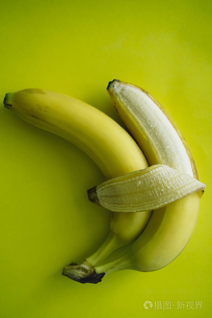 在黄色背景上分离出两根香蕉爱和温柔拥抱情侣的符号概念