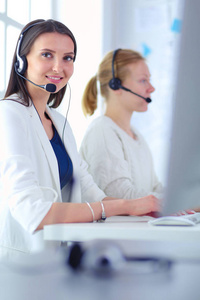 微笑的商人或热线电话操作员与耳机和计算机在办公室