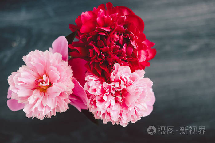 木制黑色背景上美丽的玫瑰牡丹花束. 装饰和艺术概念.