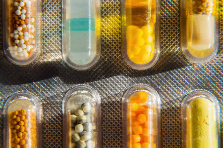 纳米药透明药物胶囊中各种五颜六色的药丸,在白色背景下分离,疾病医学