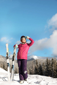 带着滑雪器材的快乐年轻女子在山里度寒假