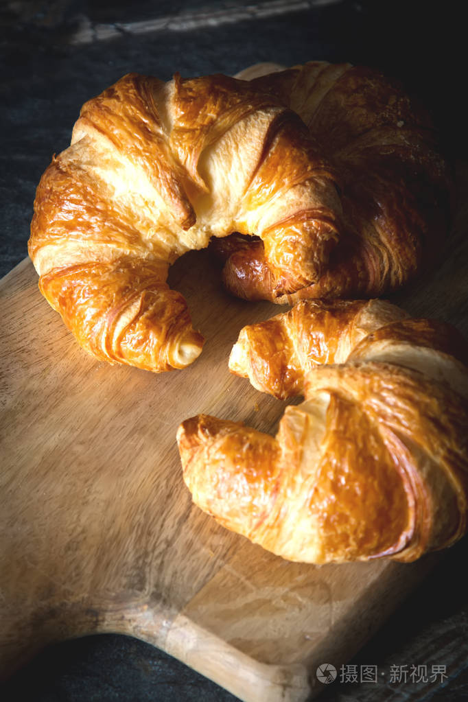 刚烤好的牛角面包在灰色的黑暗背景上. 法国菜. 早餐